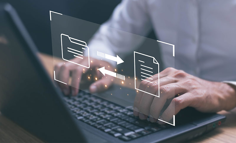 Photo of person at computer with file transfer graphics